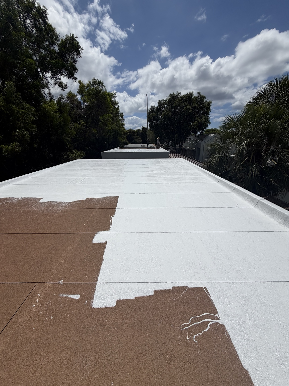 Flat commercial roof during coating prep before final white finish